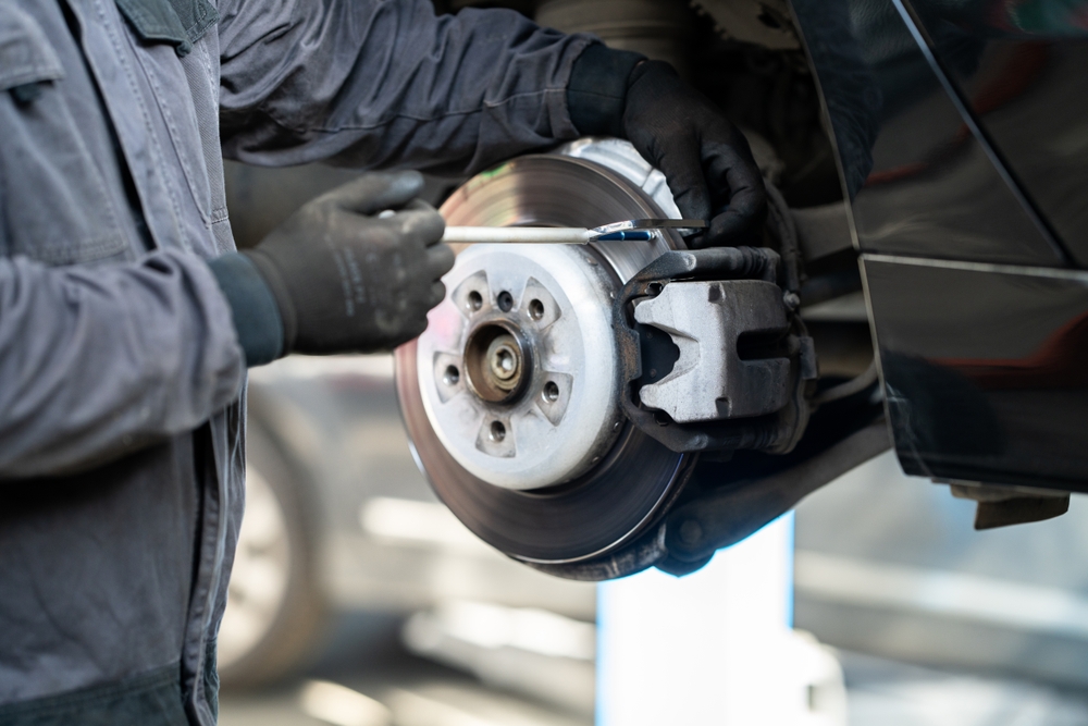 Photo of a mechanic checking the brake discs on a car.