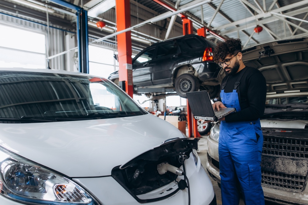 Image of a mechanic performing a diagnostic check on an electric vehicle.
